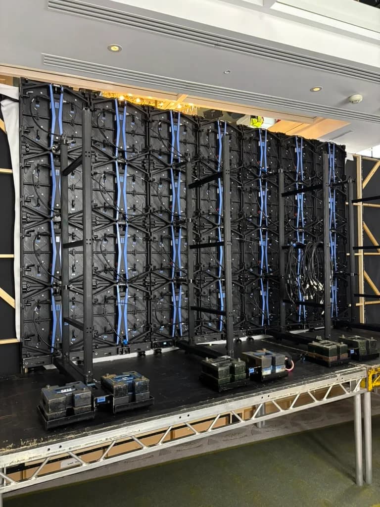 Rear of a display wall with support frames, cabling and stage weights