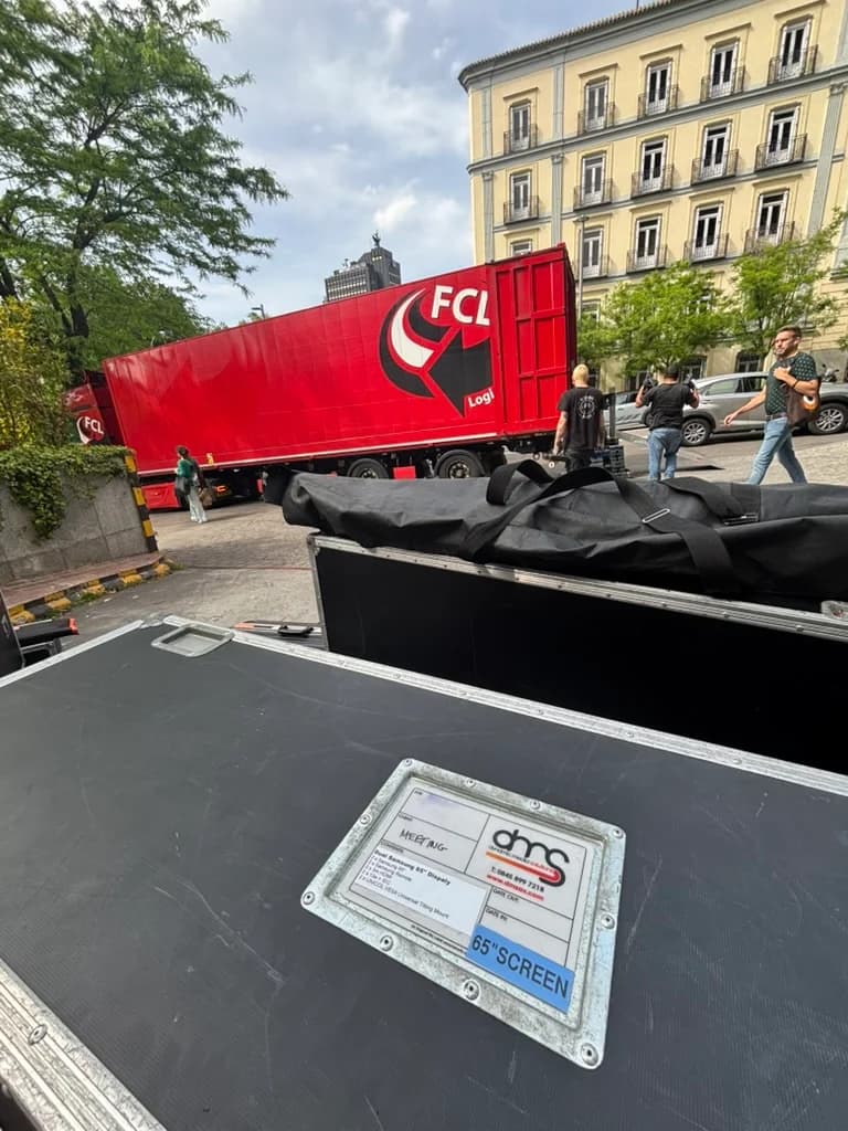 DMS flight cases beside a red lorry outside a building