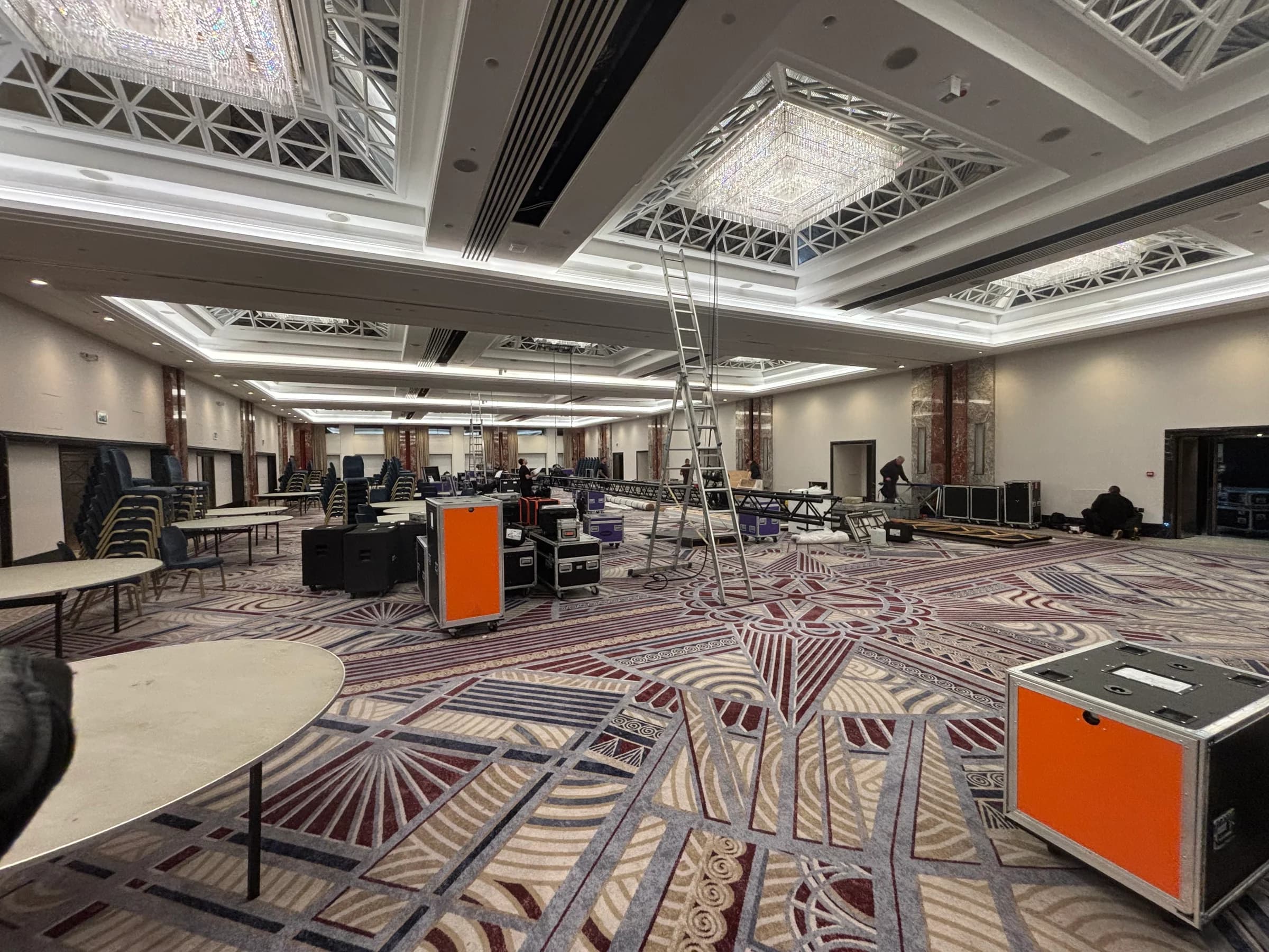 Flight cases, ladders and lighting truss in the ballroom during setup