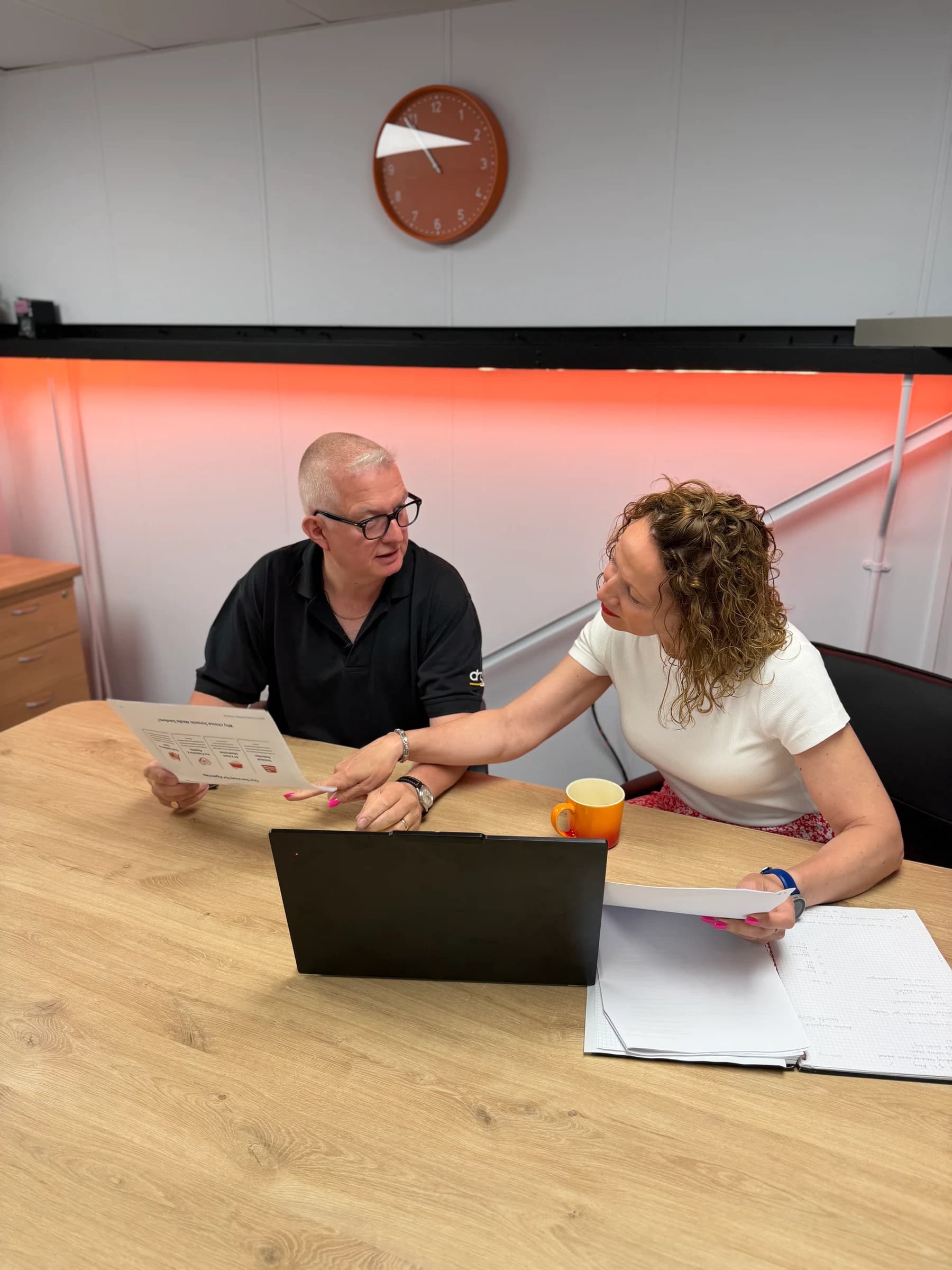 Two members of the DMS team discussing a project at a desk